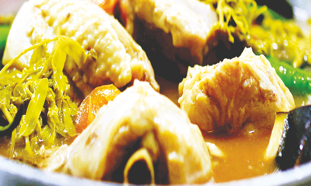 Chicken in sour tamarind broth with garlic, ginger, young tamarind leaves, and vegetables.