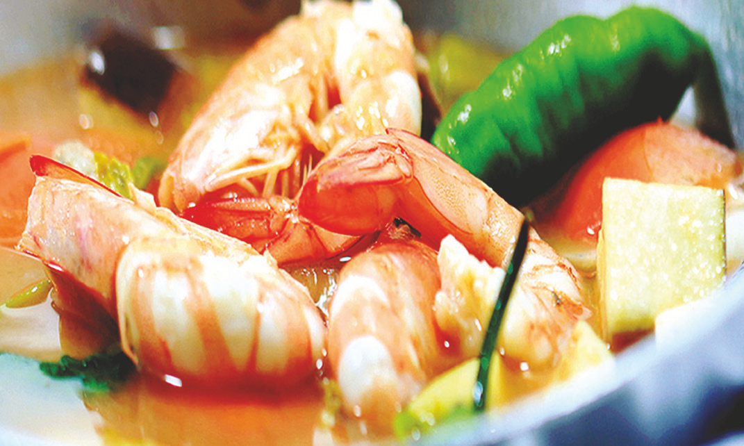 Prawns in sour tamarind broth with garlic, ginger, and vegetables.
