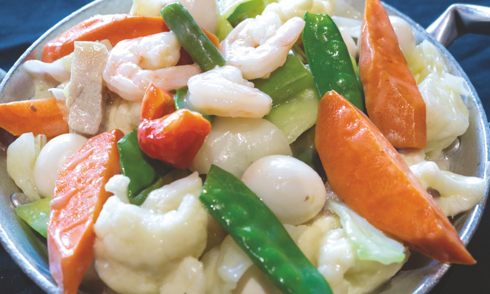 A colorful mix of cauliflower, carrots, sweet peas, green beans, bell peppers, and chayote sautéed in mushroom sauce with quail eggs, pork, and shrimp.