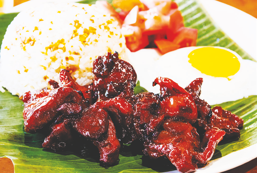 Marinated sweet pork served with rice, fried egg, and tomato