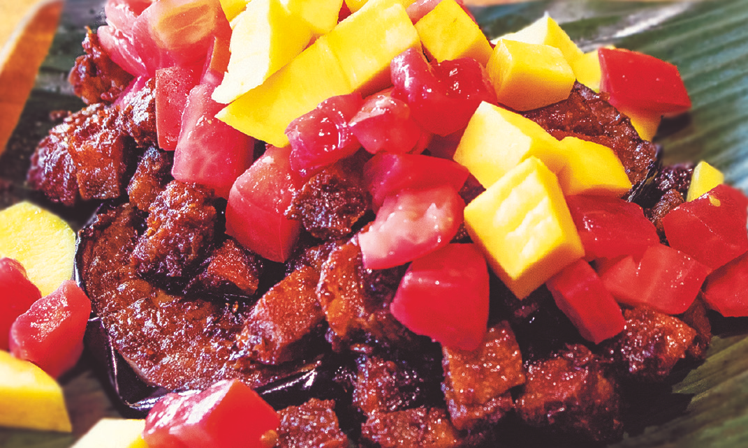 Crispy pork belly with eggplant topped with mangoes and tomatoes