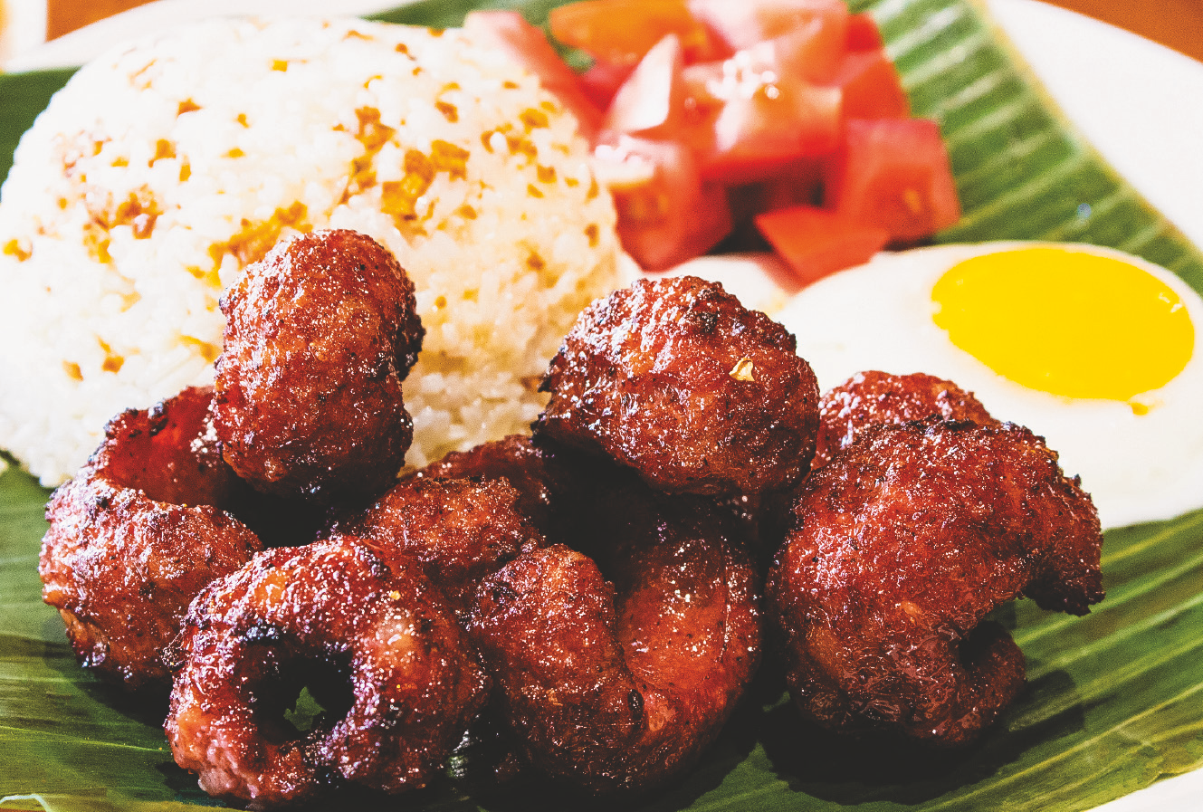 Fried sweet Filipino sausage served with rice, fried egg, and tomato