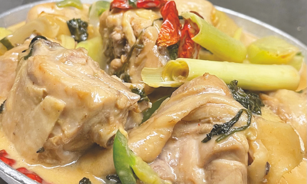 Chicken in spicy coconut sauce with ginger, chayote, lemongrass, and leafy vegetables.