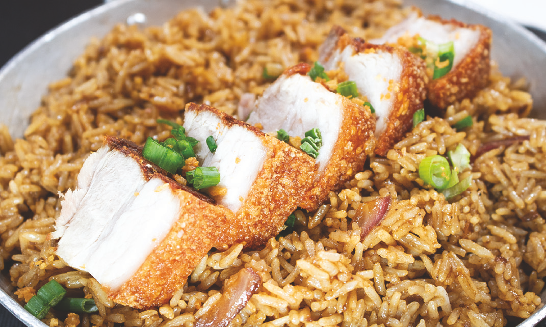 Steamed rice in adobo sauce topped with crispy pork belly