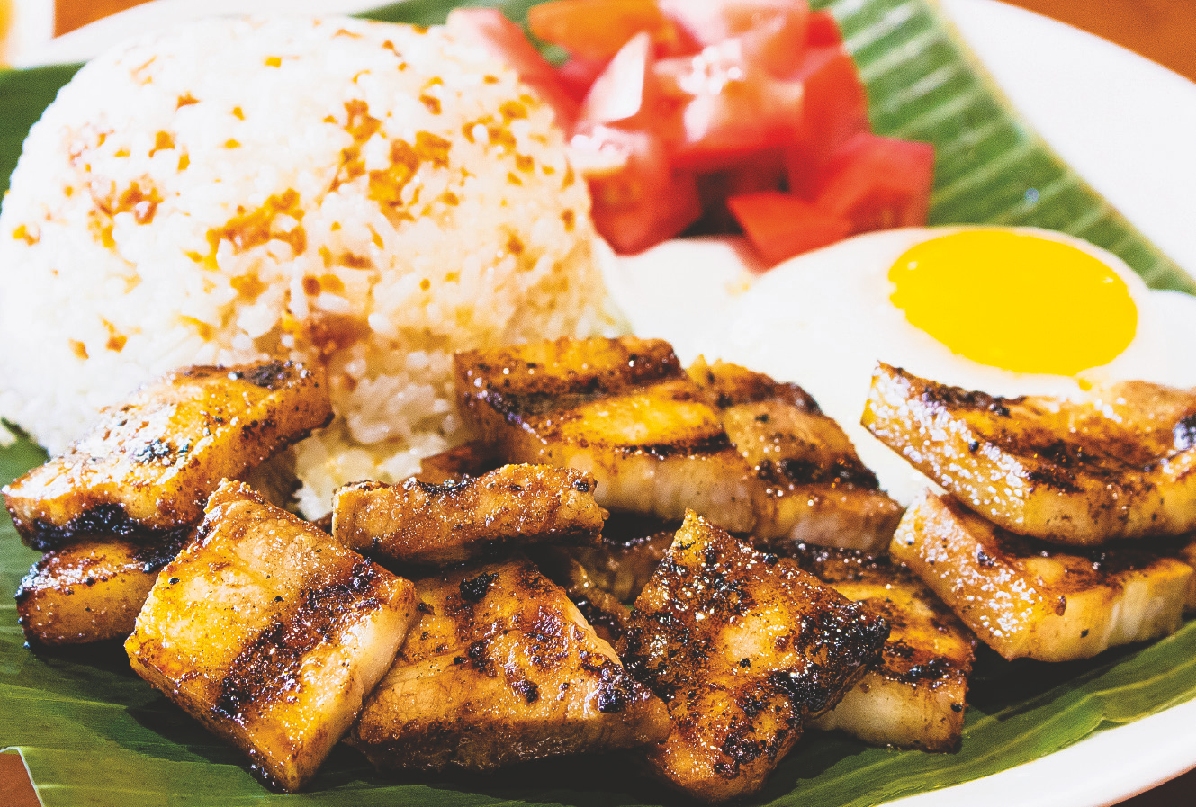 Grilled marinated pork belly served with rice, fried egg, and tomato