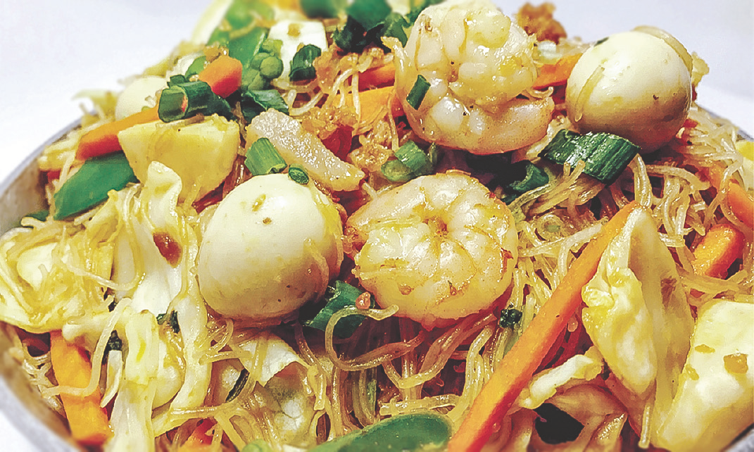 Thin rice stick noodles cooked with pork, quail eggs, squid balls, shrimp, and vegetables.
