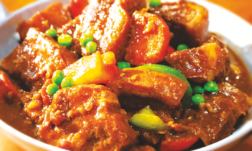 Spicy pork belly stew with carrots, green peas, bell peppers, and potatoes