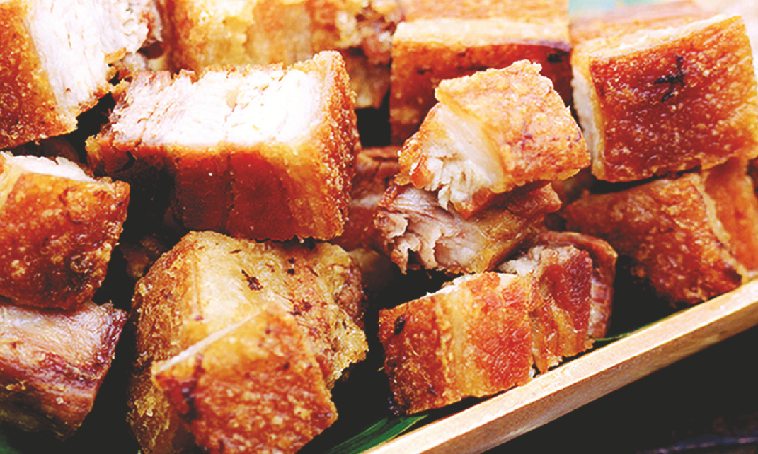 Deep‑fried pork belly served with spiced vinegar or lechon sauce