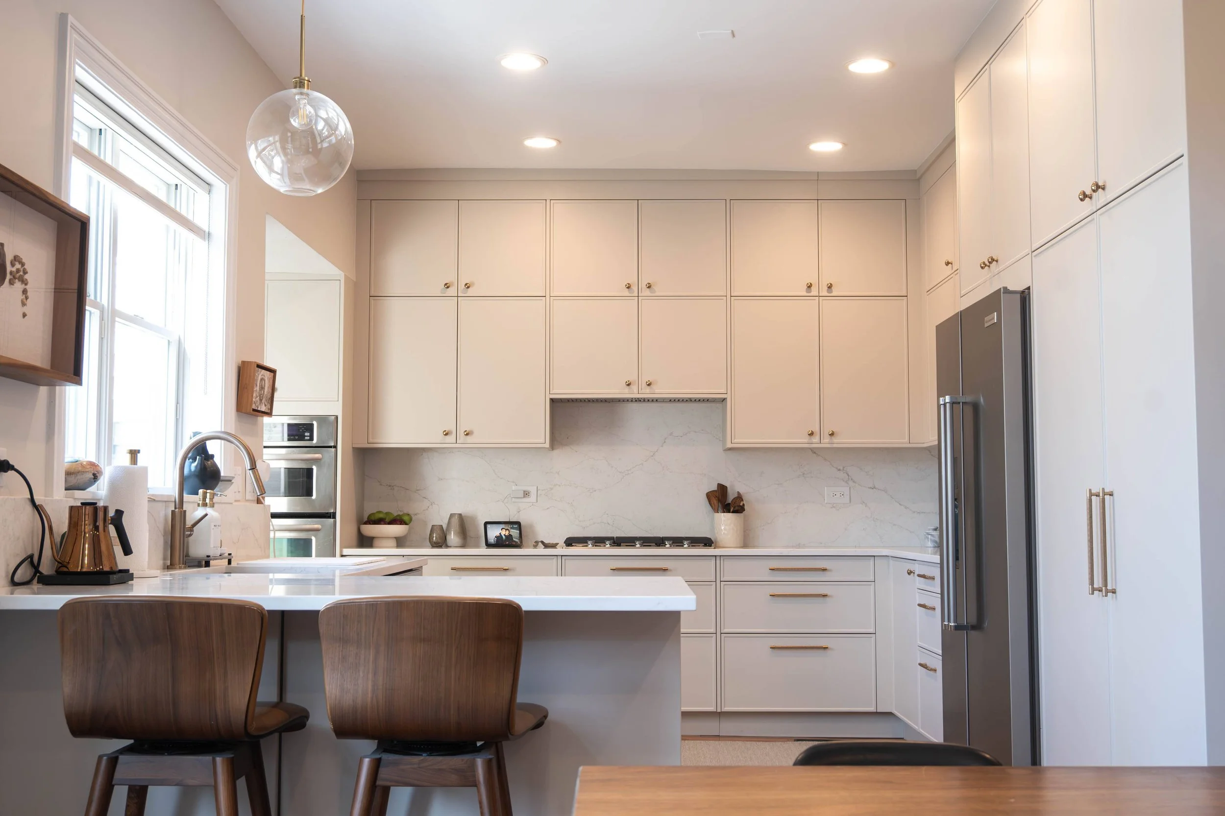 An expansive open-concept kitchen remodel in Chicago featuring pristine white cabinetry, a spacious central island, and a layout designed for modern entertaining.