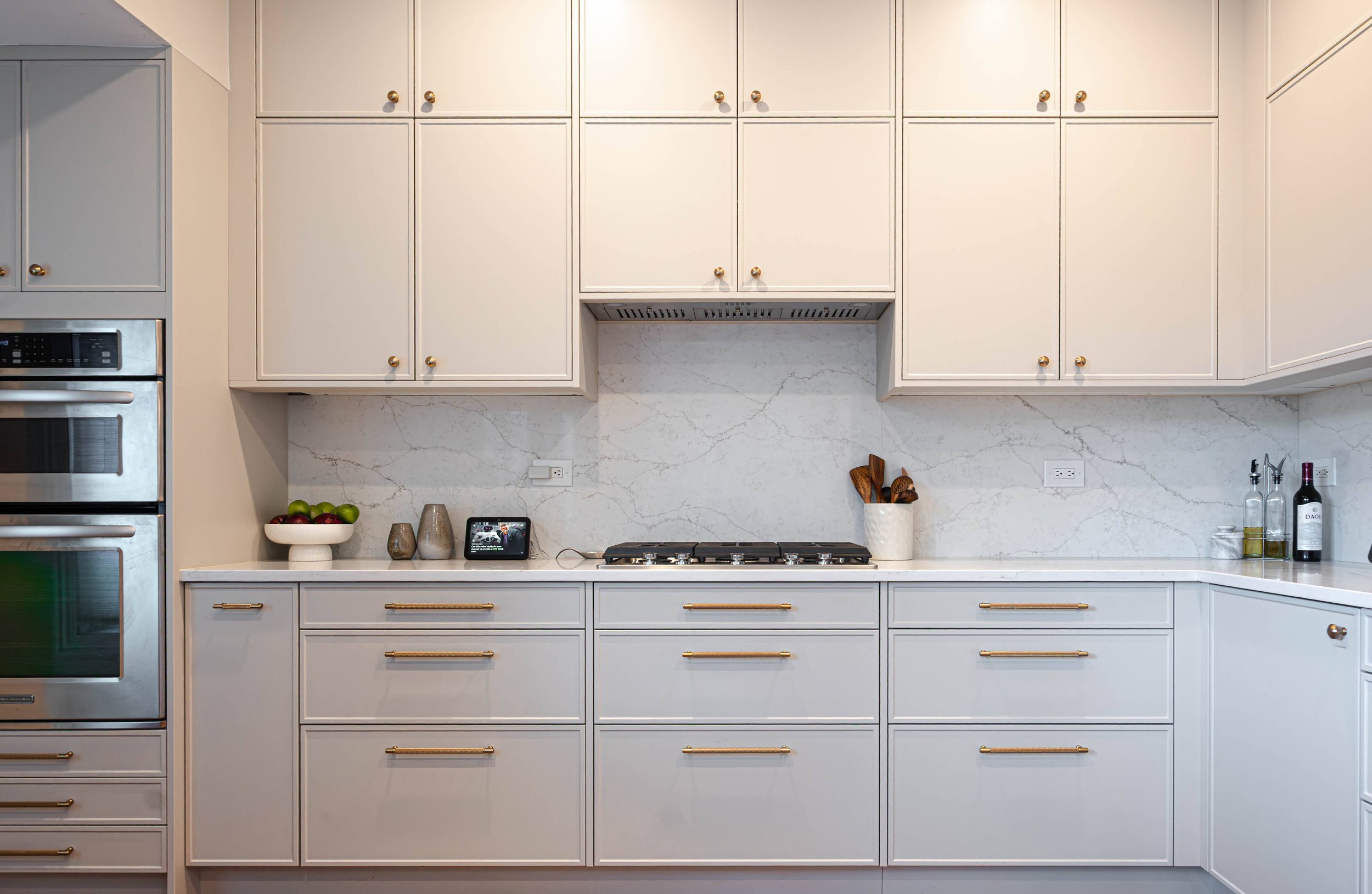 A symmetrical chef's kitchen layout highlighting a built-in vertical wall oven, premium quartz countertops, and efficient cabinetry design.