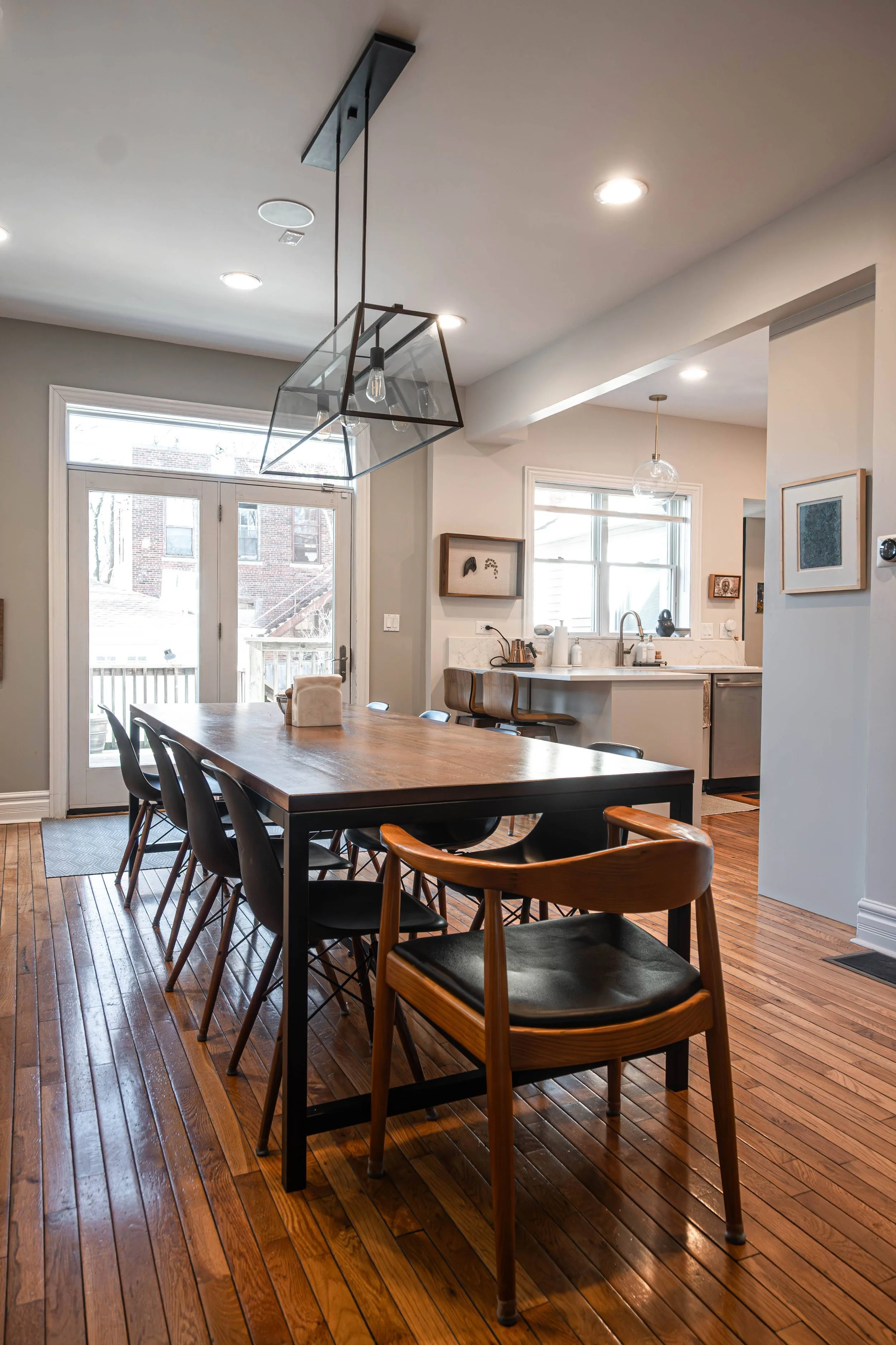 A formal yet modern dining space in Chicago, illuminated by contemporary fixtures and drenched in natural sunlight.