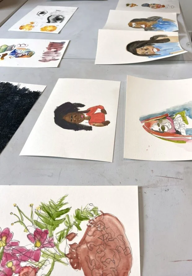 Collection of watercolor and ink sketches of various subjects on paper sheets, including portraits of women, a colorful abstract figure, and a floral illustration.