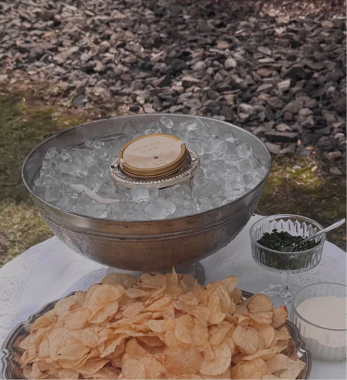 Black Pearl Beluga Caviar on ice with chips, creme fraiche and dill on a table with white linen - SHuck Yeah Oyster Catering