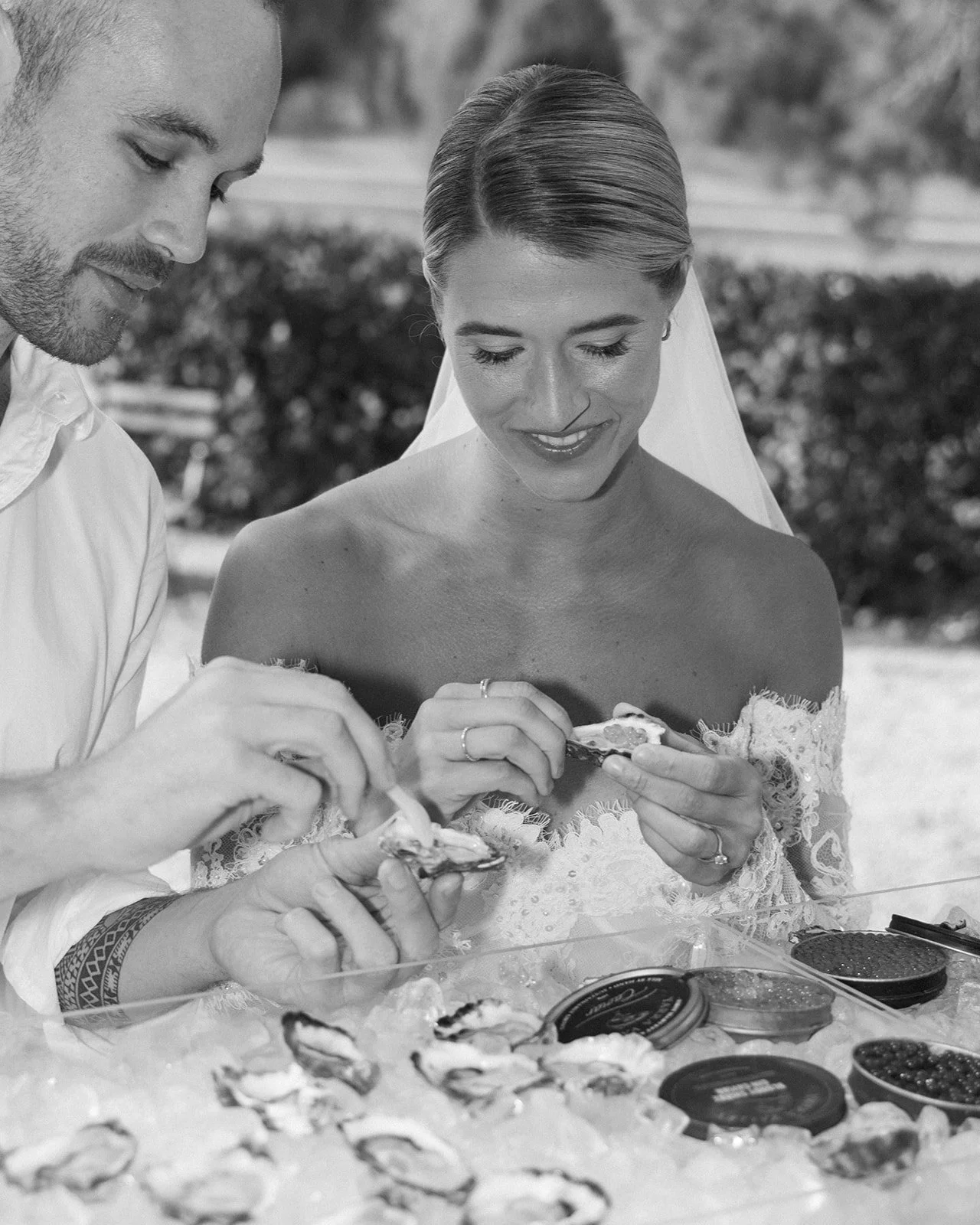 Bride and groom enjoying freshly shucked oysters during wedding cocktail hour - Shuck Yeah Oyster Catering