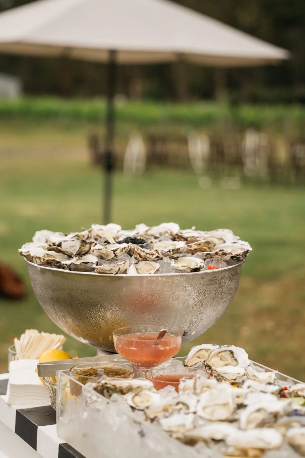 Oysters displayed in silver champagne bowl with condiments and lemons. Oyster bar catering Hunter Valley NSW