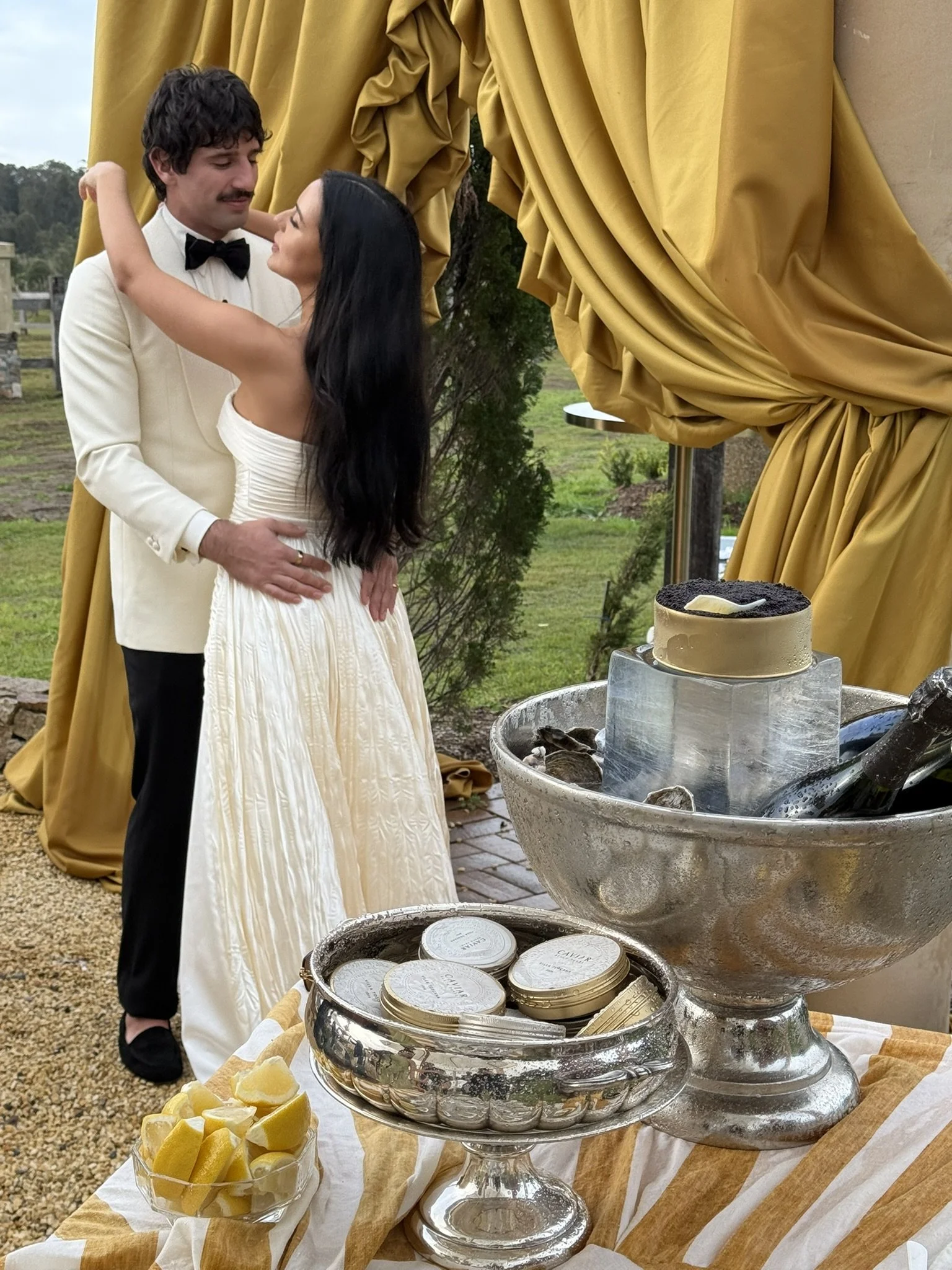 Wedding couple in the background, caviar and champage on ice in foreground. Hunter Valley Wedding Catering