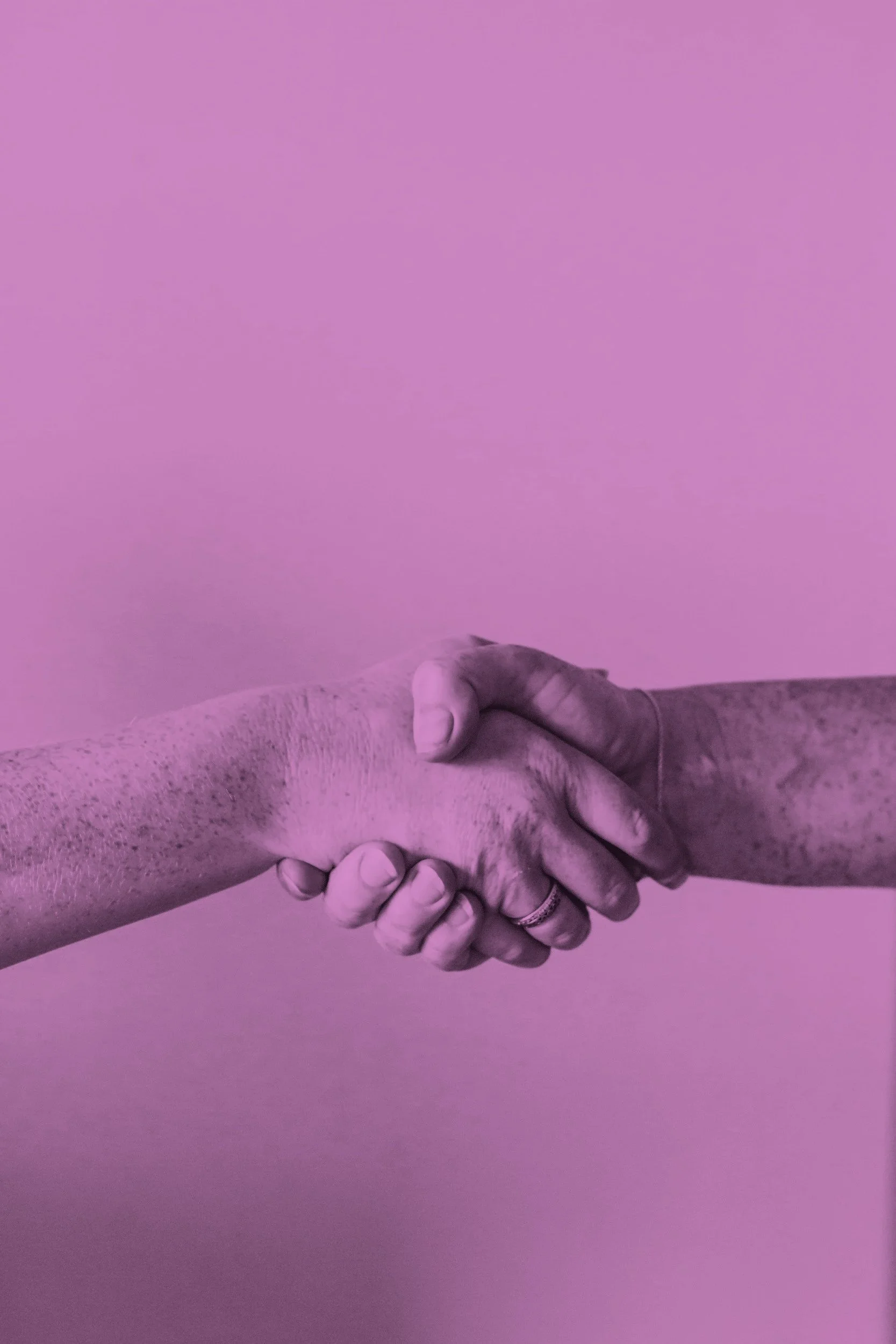 Two hands shaking against a pink background.