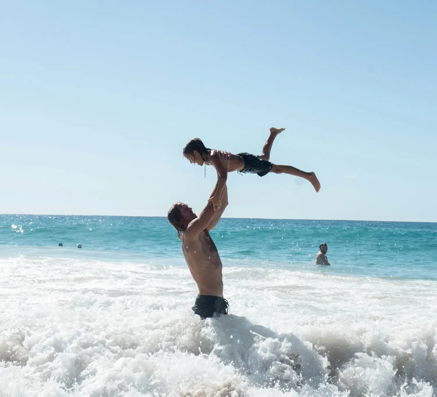 Dad playing with child in the surf