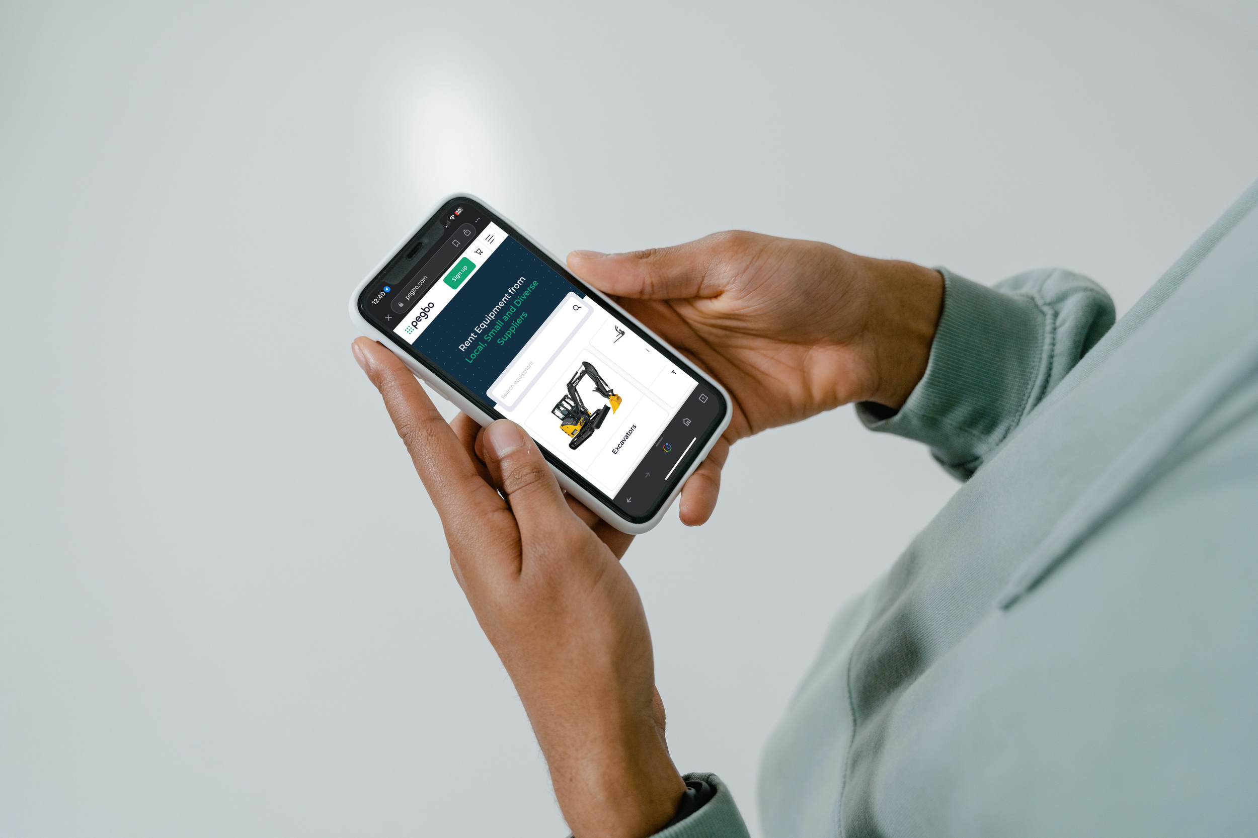 Person holding a smartphone browsing an online equipment rental website.