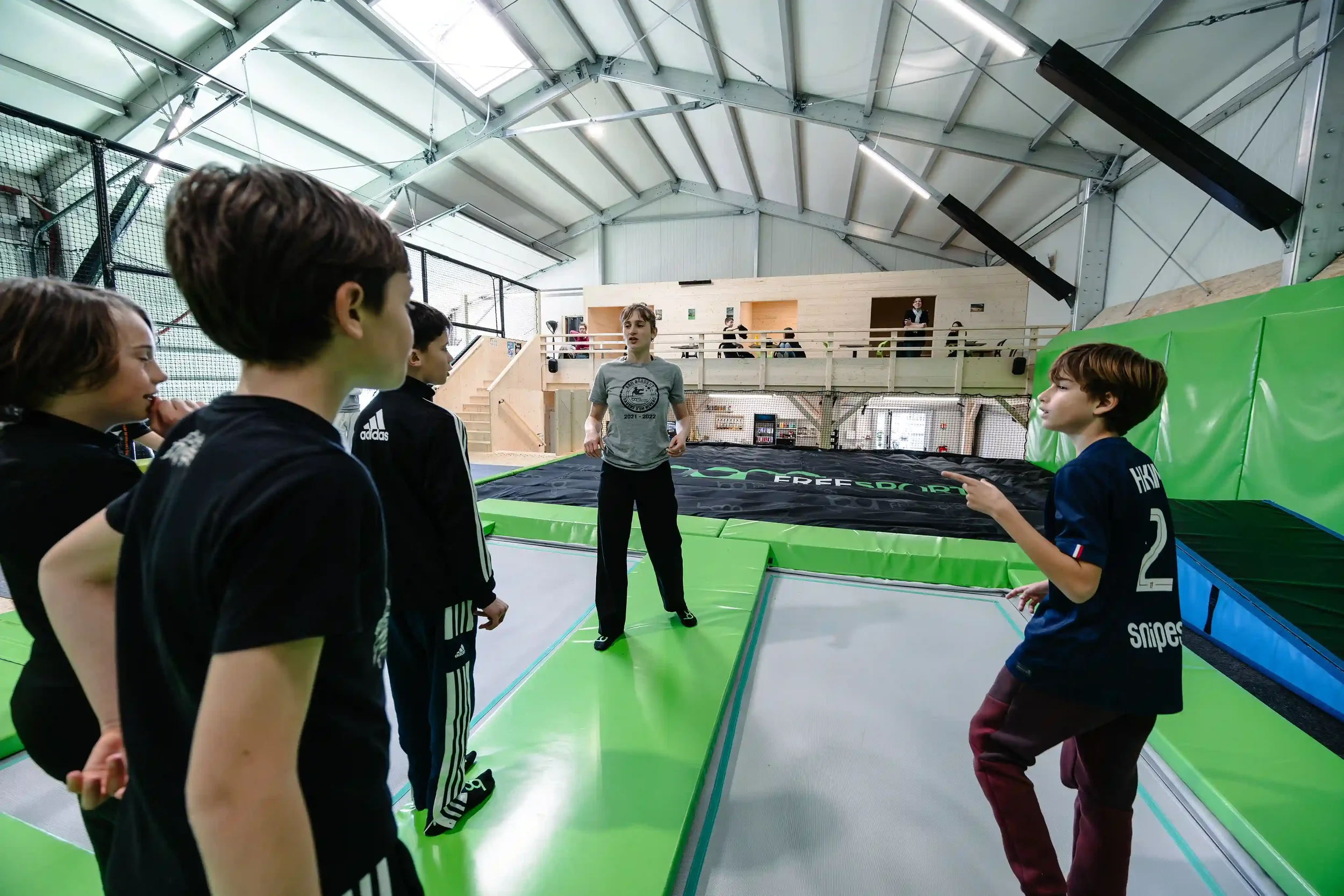 Staff de BAM FREESPORTS ANNECY qui explique des choses aux enfants sur des trampolines