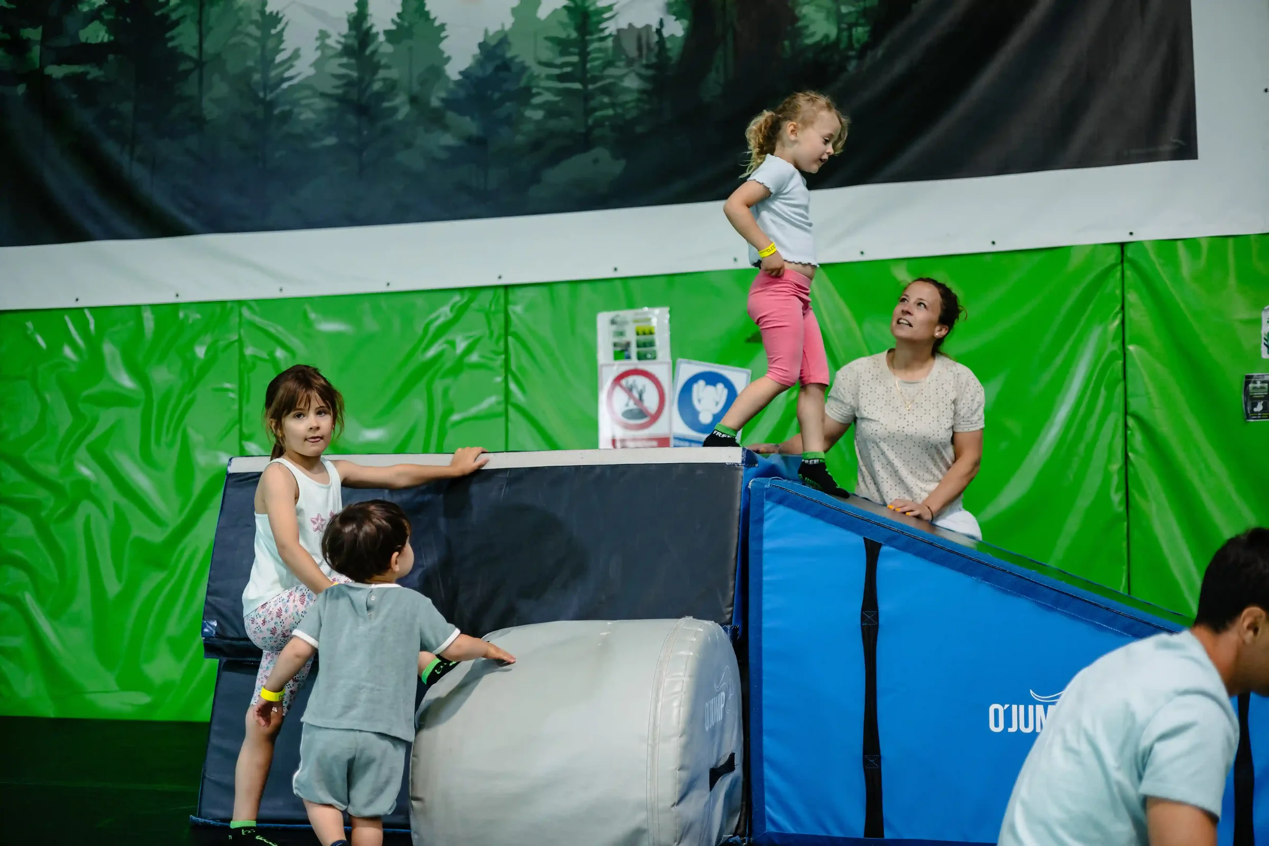 Enfants dans la salle de trampoline de BAM FREESPORTS qui s'amusent sous le regard de leurs parents.