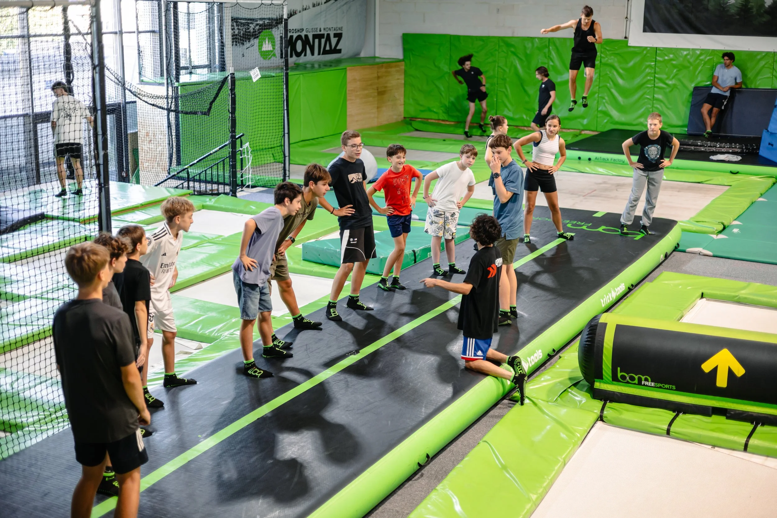 Groupe de jeunes enfants qui suivent un échauffement avant d'aller sur les trampolines