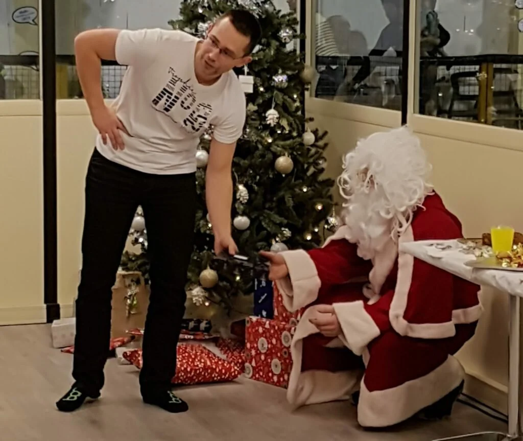Père Noël qui donne un cadeau à un salarié d'une lors d'un Noël d'entreprise.