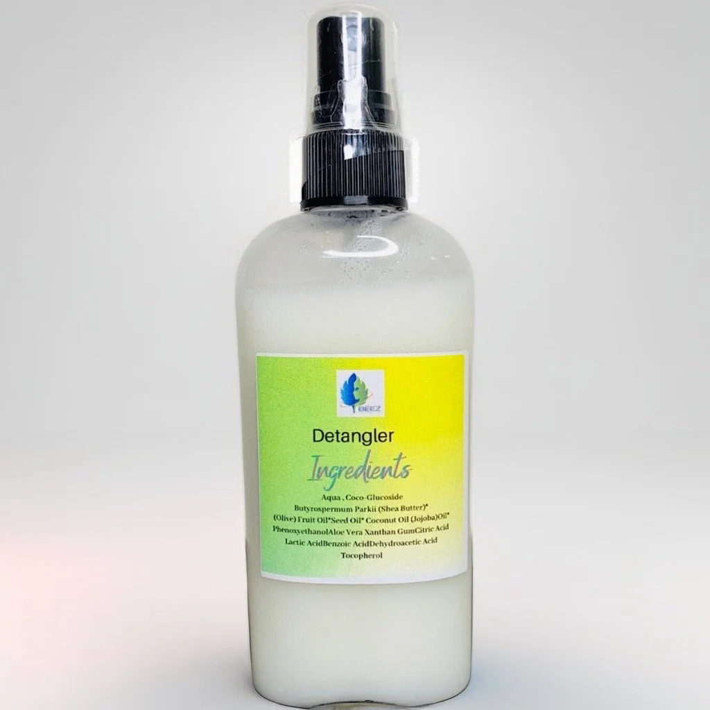 A white spray bottle labeled "Detangler Ingredients" with a black spray nozzle.