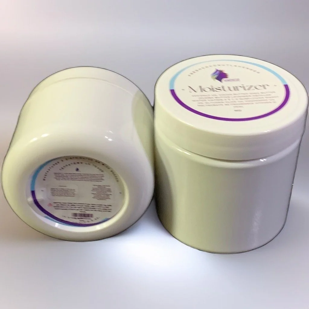 Two white containers of moisturizing cream, one open and one closed, with purple, blue, and green label on top.