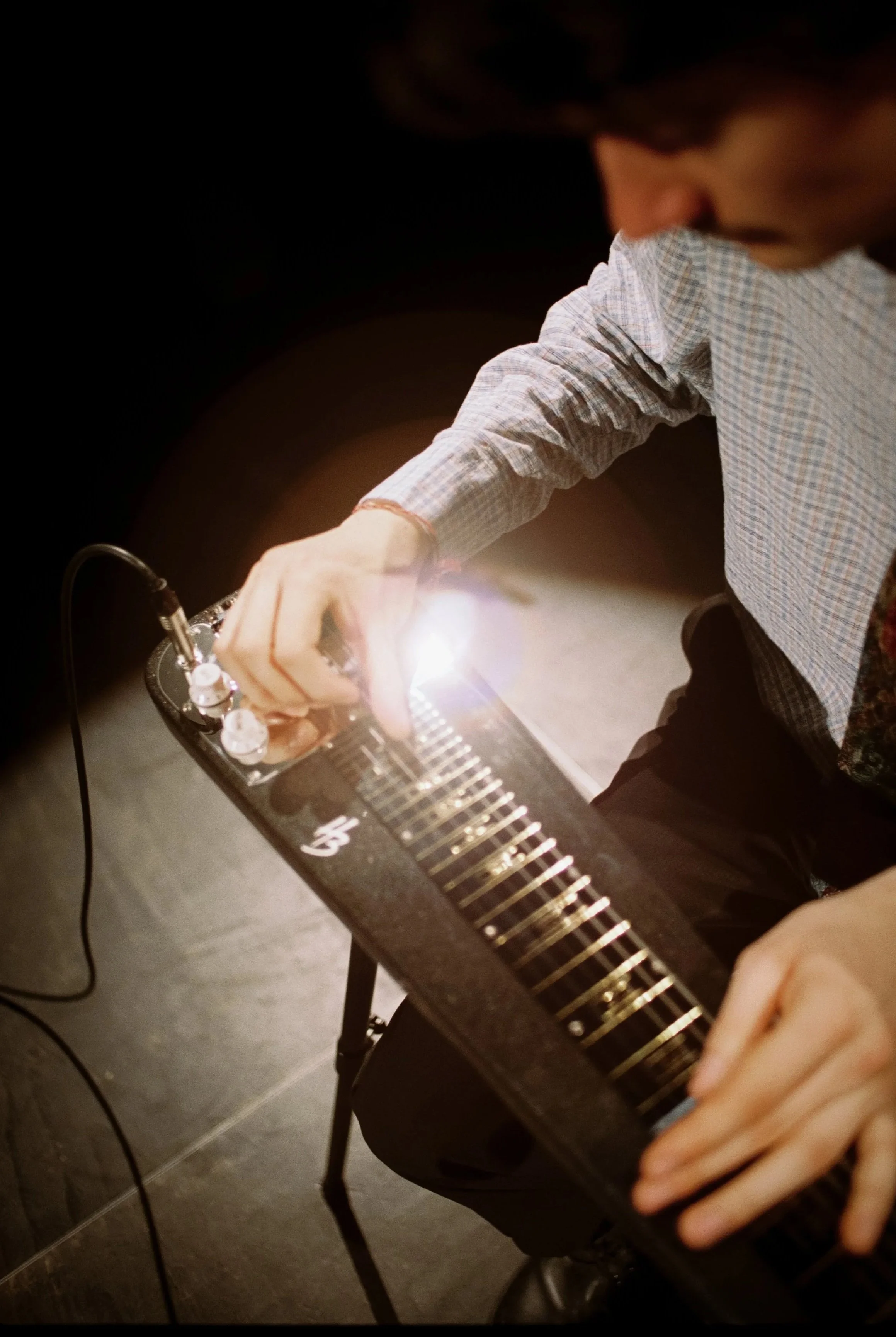 Ein Mann spielt auf einem elektronischen Musikinstrument, das mit leuchtenden Lichtern und Reglern versehen ist.