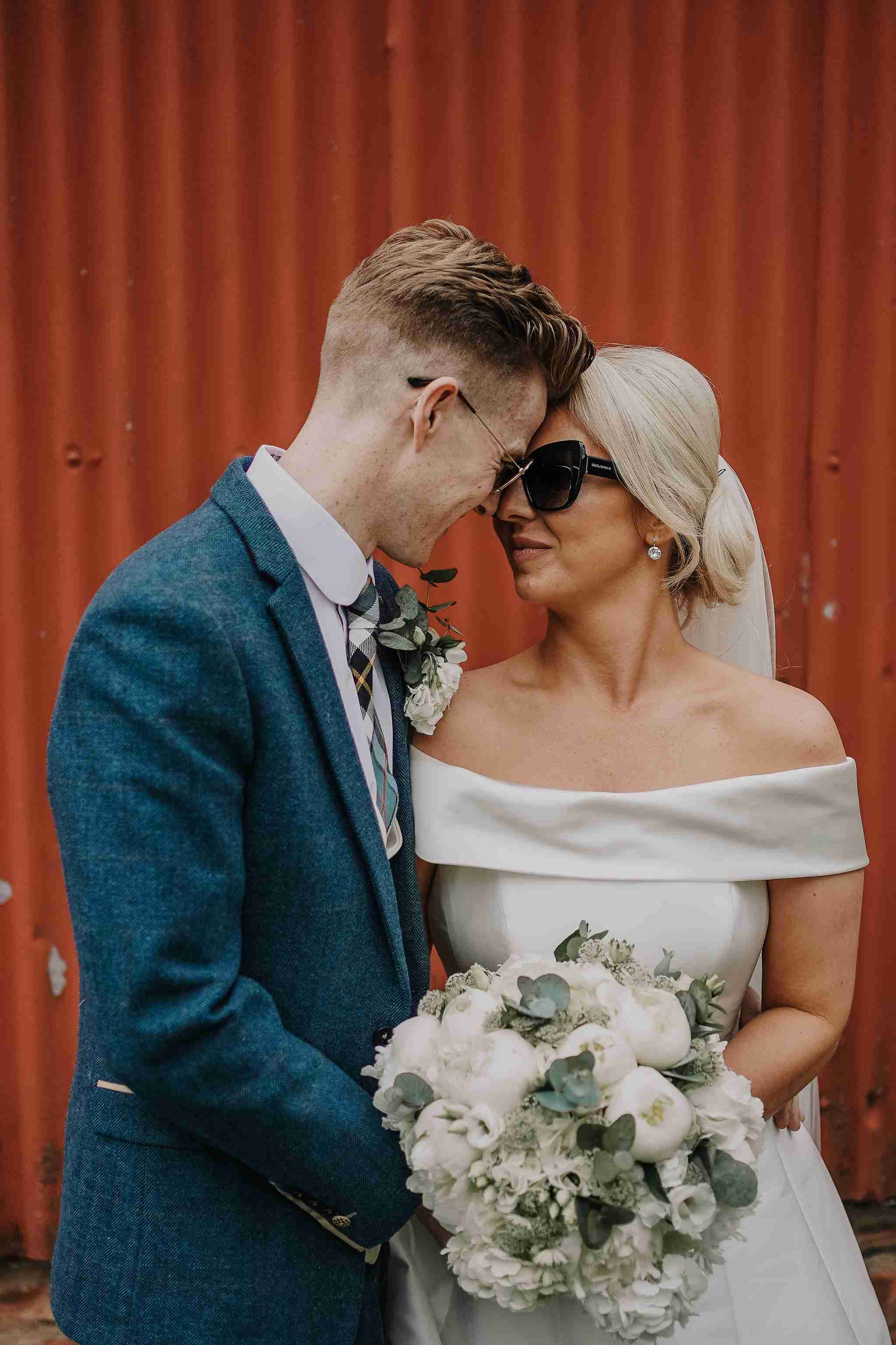 Bride and groom with the red backdrop at their wedding