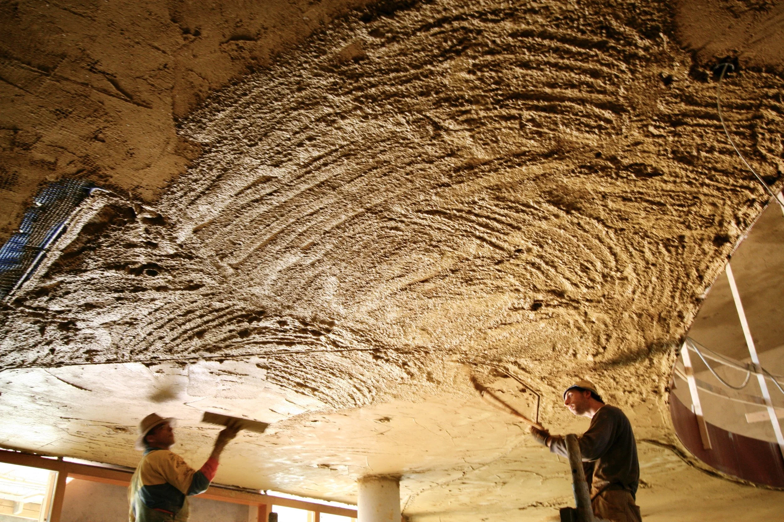 spraying clay plaster adobe build