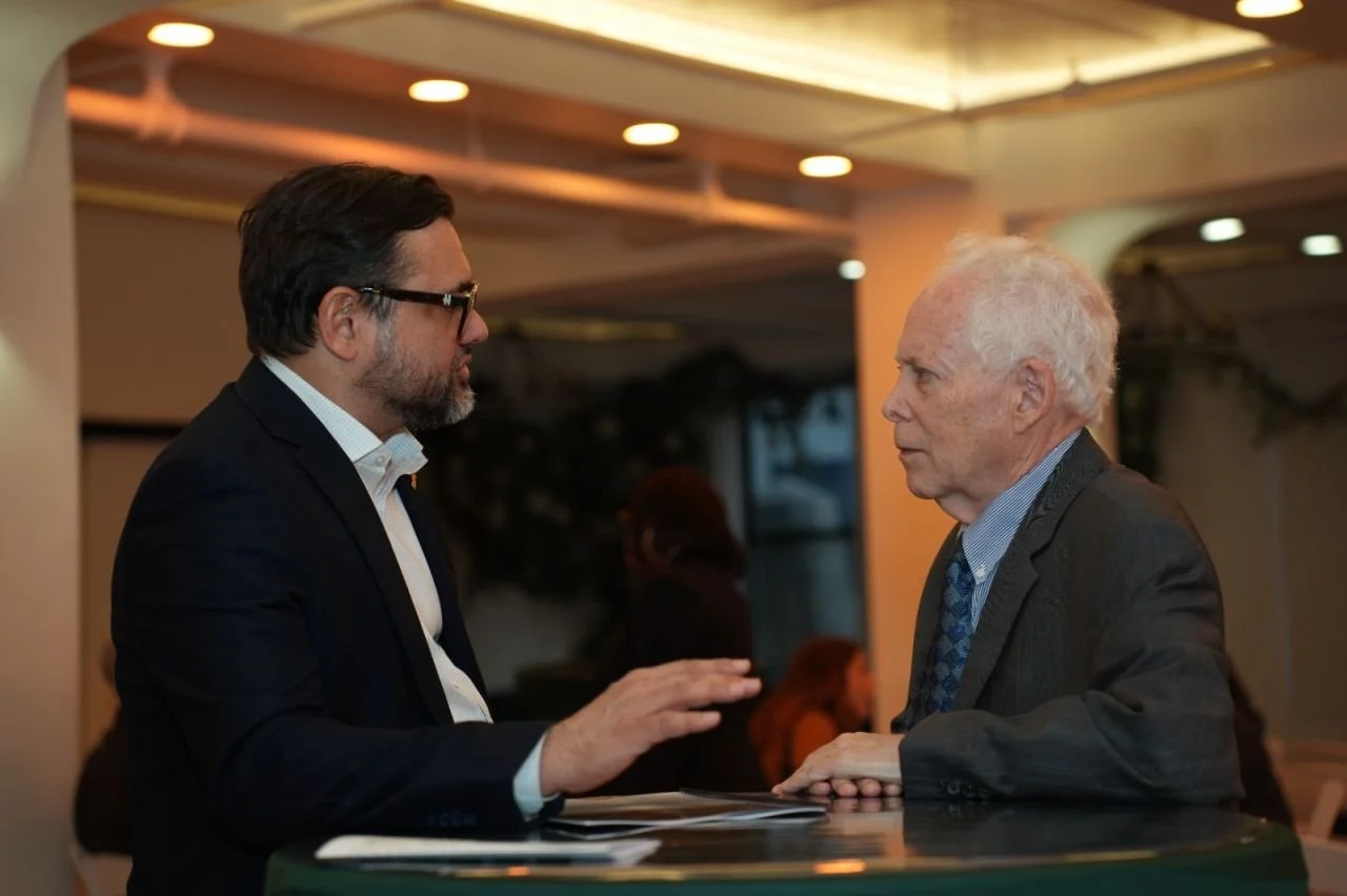Two attendees in conversation at a high-top table