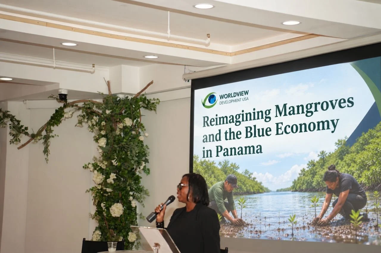 Monaqui Porter Young speaking at a microphone beside a slide reading Reimagining Mangroves and the Blue Economy in Panama