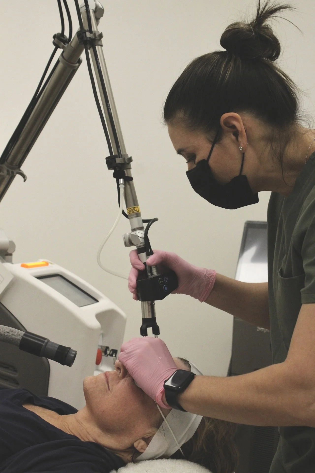 Provider performing CO2 laser facial treatment to improve skin tone, fine lines, and acne scars