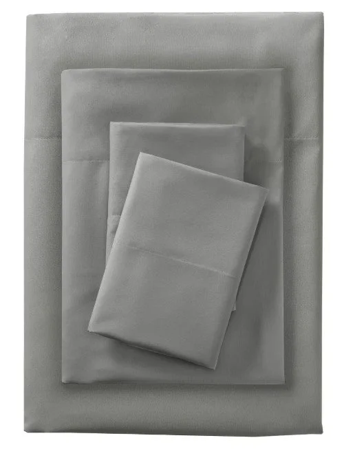 Three folded gray bedsheets on a larger gray bed sheet set against a gray background.