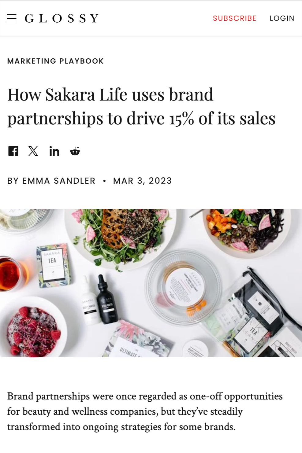 A webpage article titled 'How Sakara Life uses brand partnerships to drive 15% of its sales' with an image showing various bowls of healthy food, tea boxes, skincare products, and a glass of tea on a white surface.