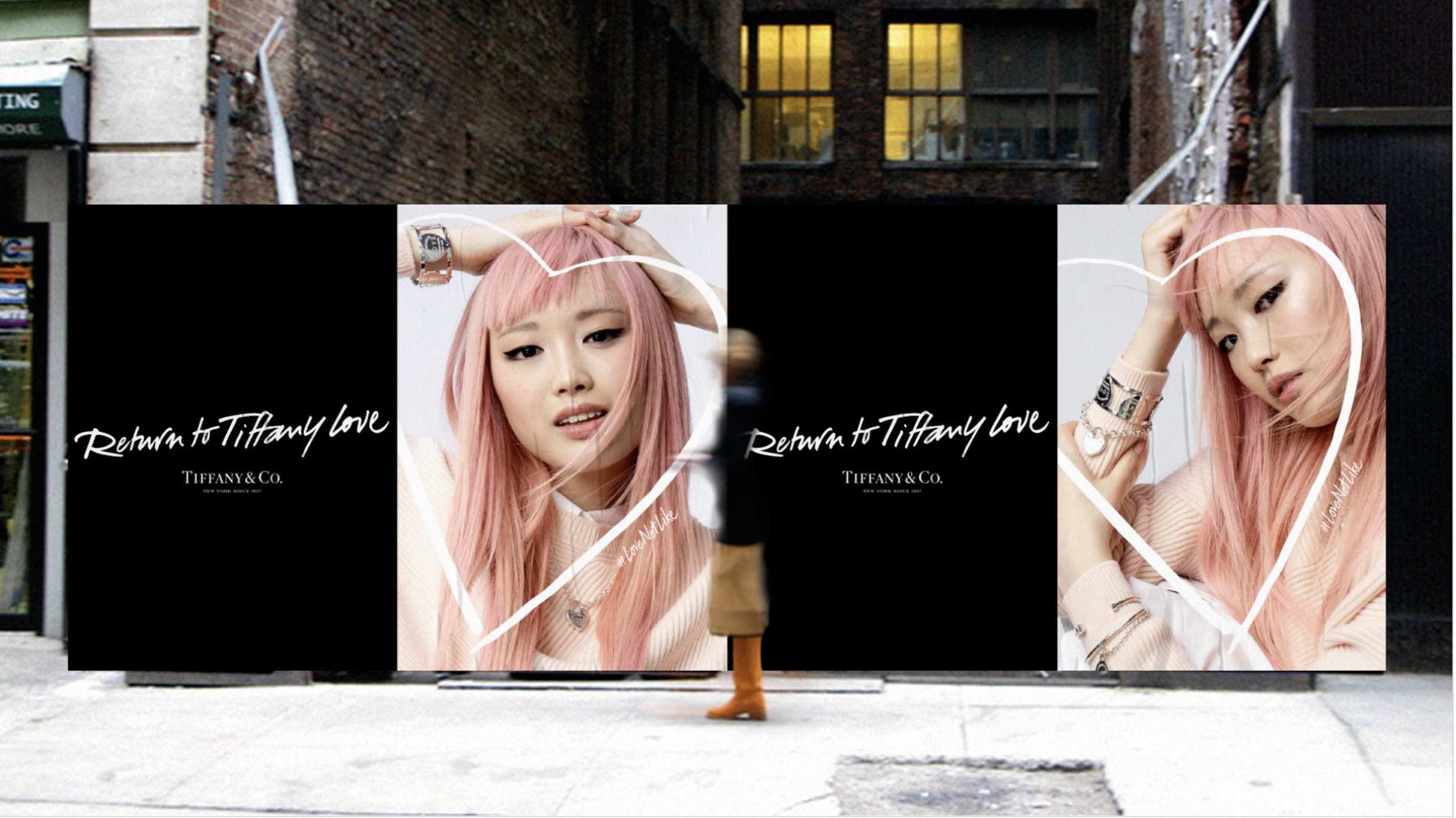 Large billboard on a city sidewalk featuring two models with pink hair and jewelry, with the phrase "Return to Tiffany Love" and Tiffany & Co. branding, set against an urban backdrop.