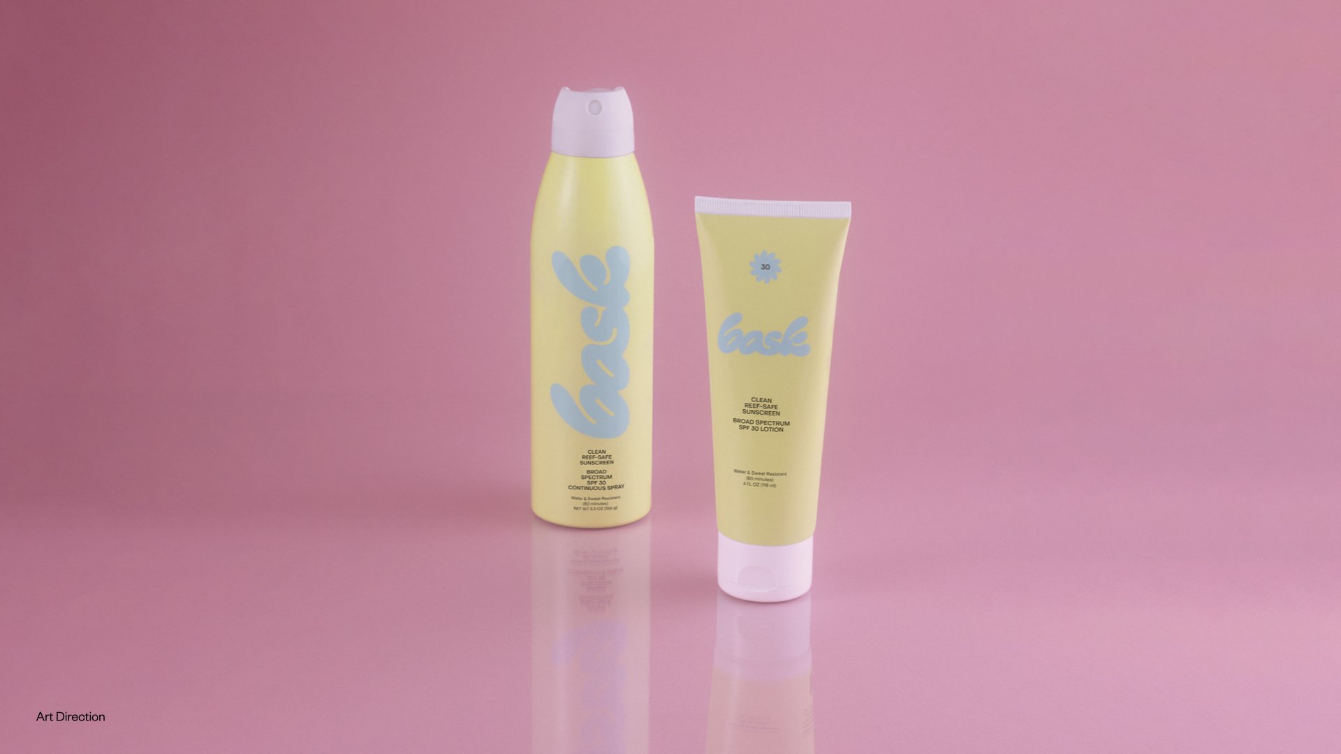 Two bottles of skincare products, one spray and one lotion, with yellow packaging and blue lettering that says 'coast,' set against a pink background.