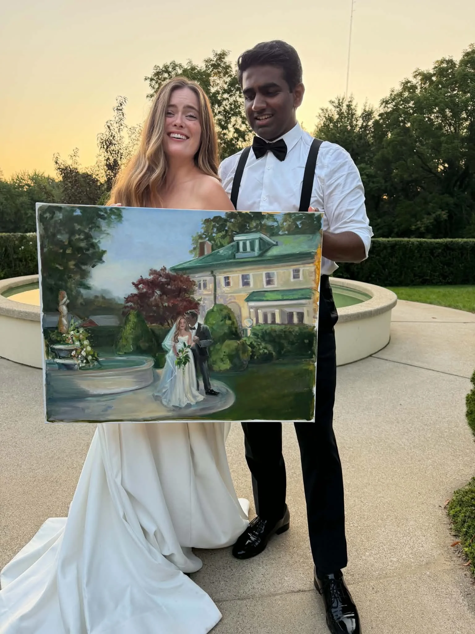 Newly wed couple looking excitedly at their live wedding painting