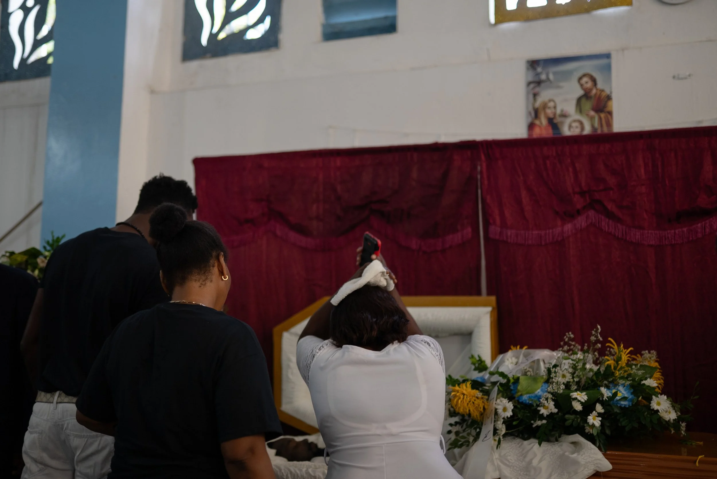 Mourners at the funeral of Johnny Alexis, 33.