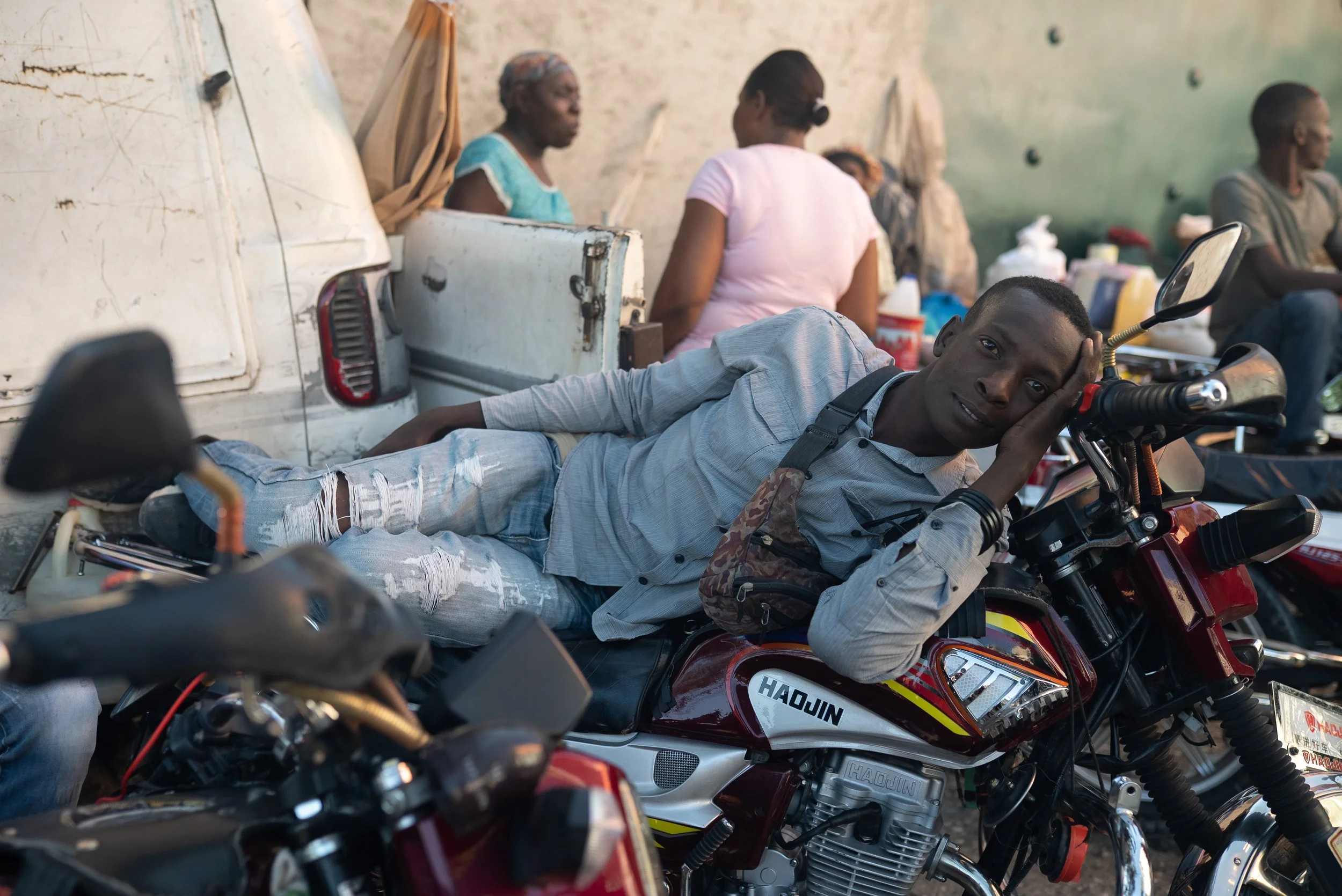 Motorcycle taxi drivers like Nessli, 32, knows he "can die doing this." Before he would have 10 clients a day, now has three if he is lucky. There's a fear that stays with you when one of your friend dies doing this work, he says. Nessli rests on his