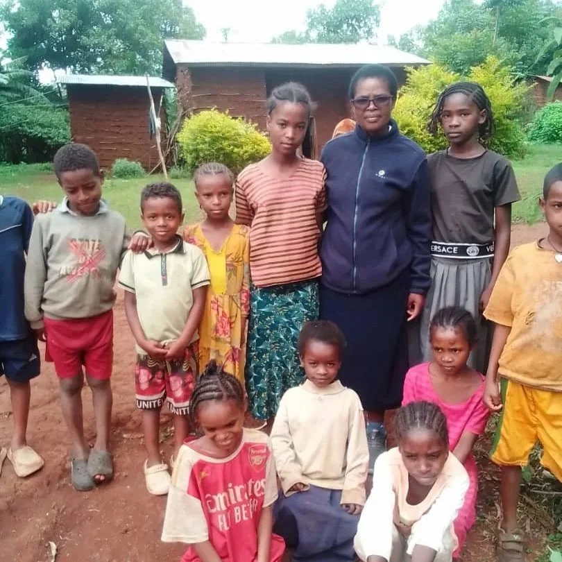 Novice Maureen Anyega visits with the children 