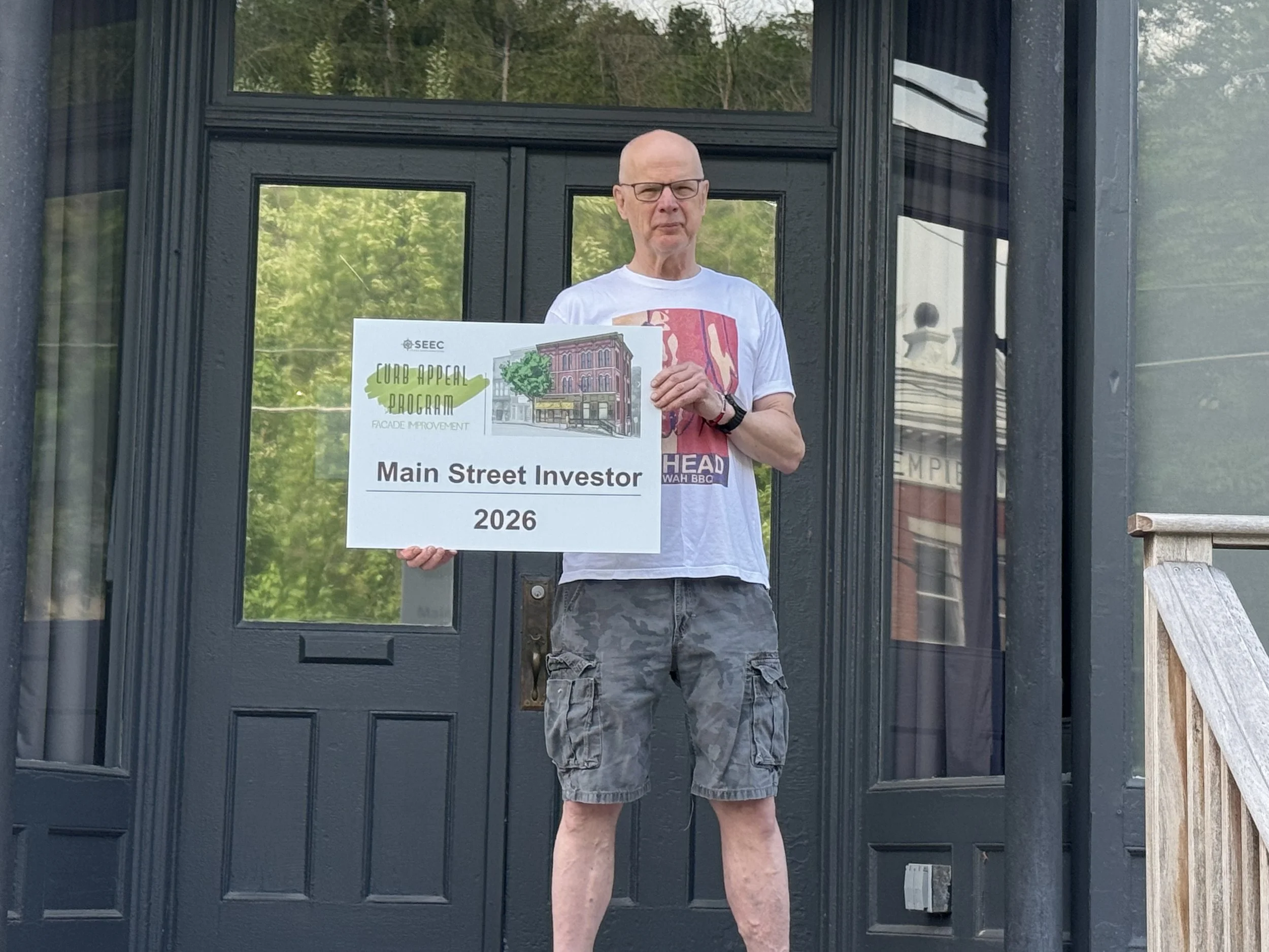 Jim outside 204 with Sign.jpeg