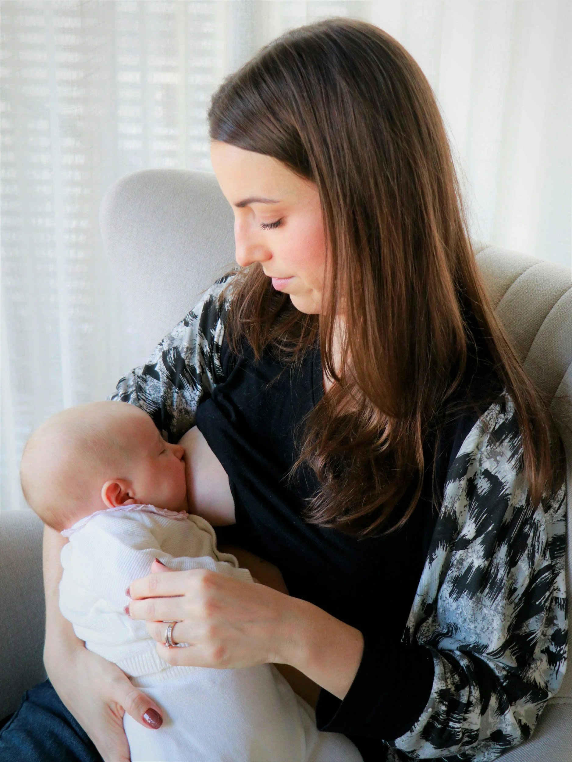 White woman with brown hair breastfeeding her baby