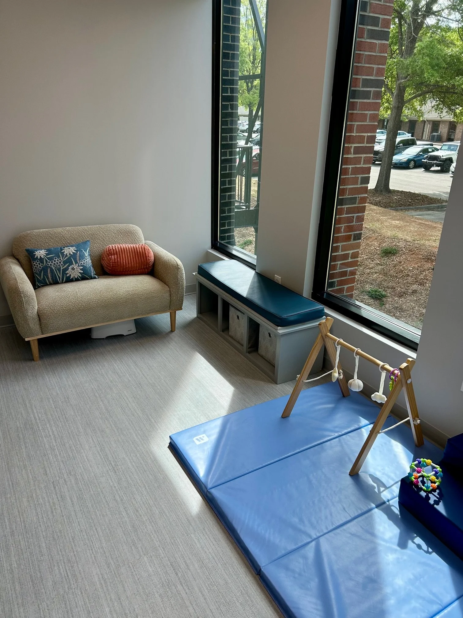 bwellbaby office space with couch, play mat and toys