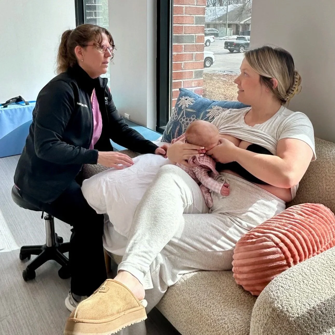 lactation consultant talking with mother who is breastfeeding