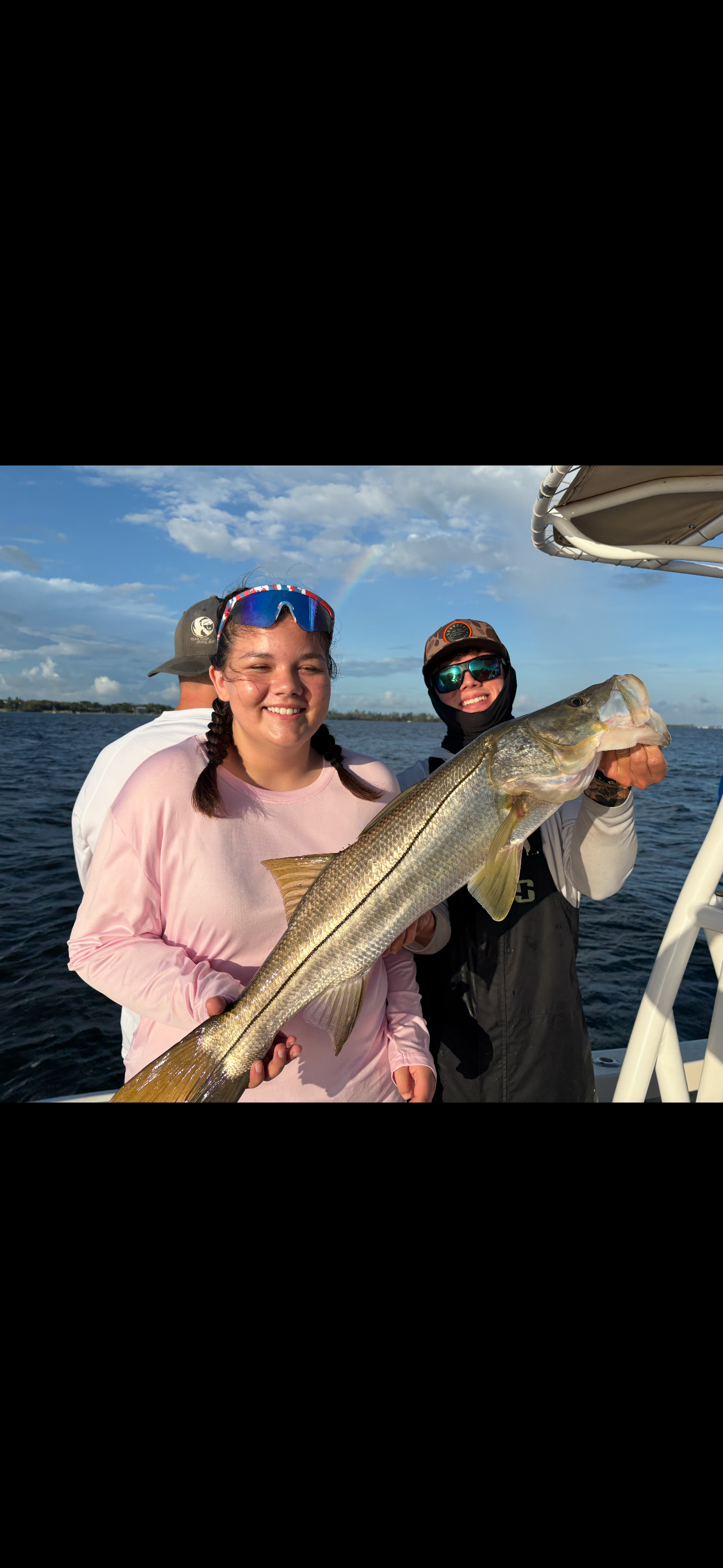 Motorboat on a body of water with a bridge in the background