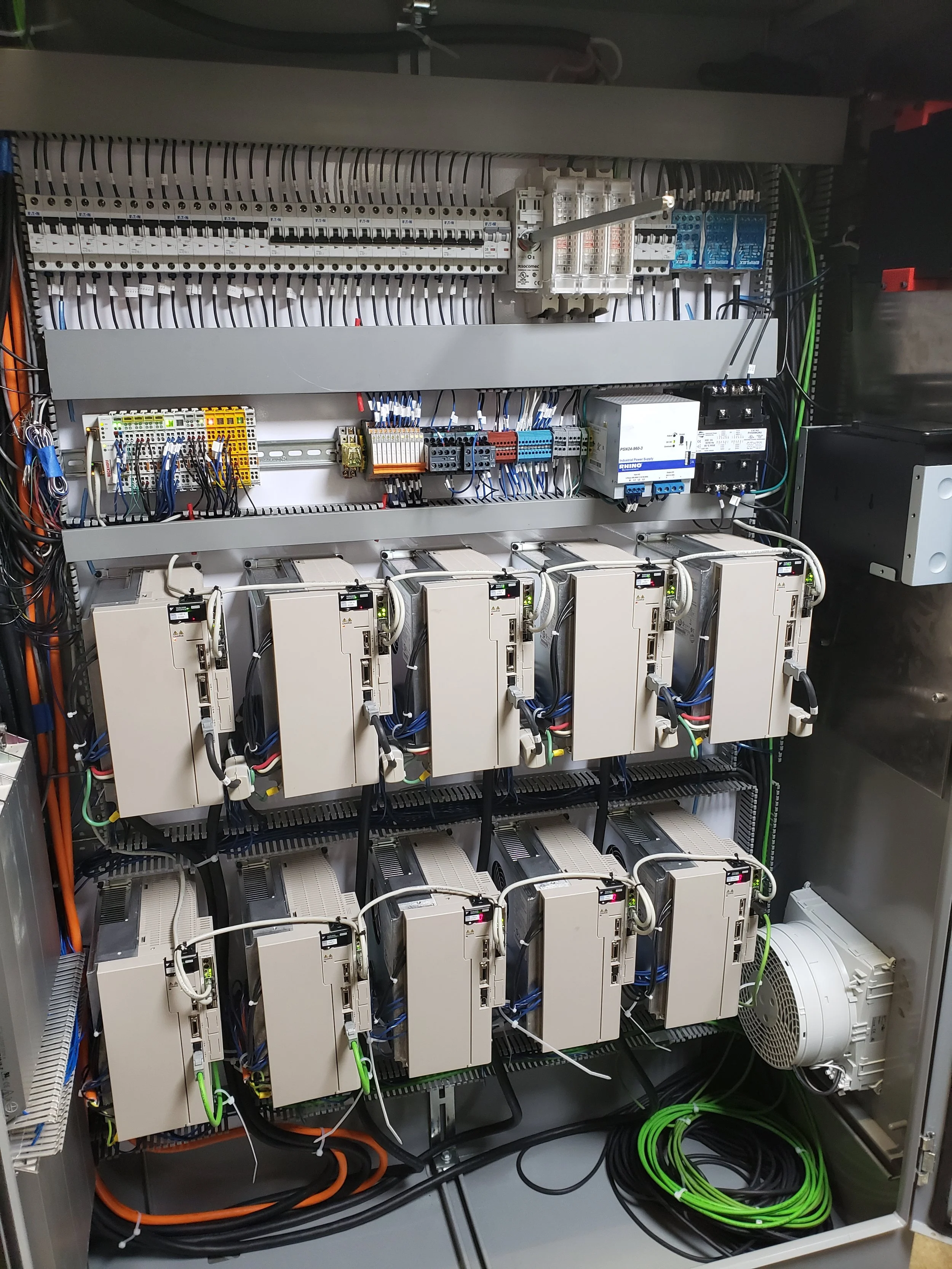 An electrical control panel containing circuit breakers, relays, and wiring organized in rows with various colored wires.