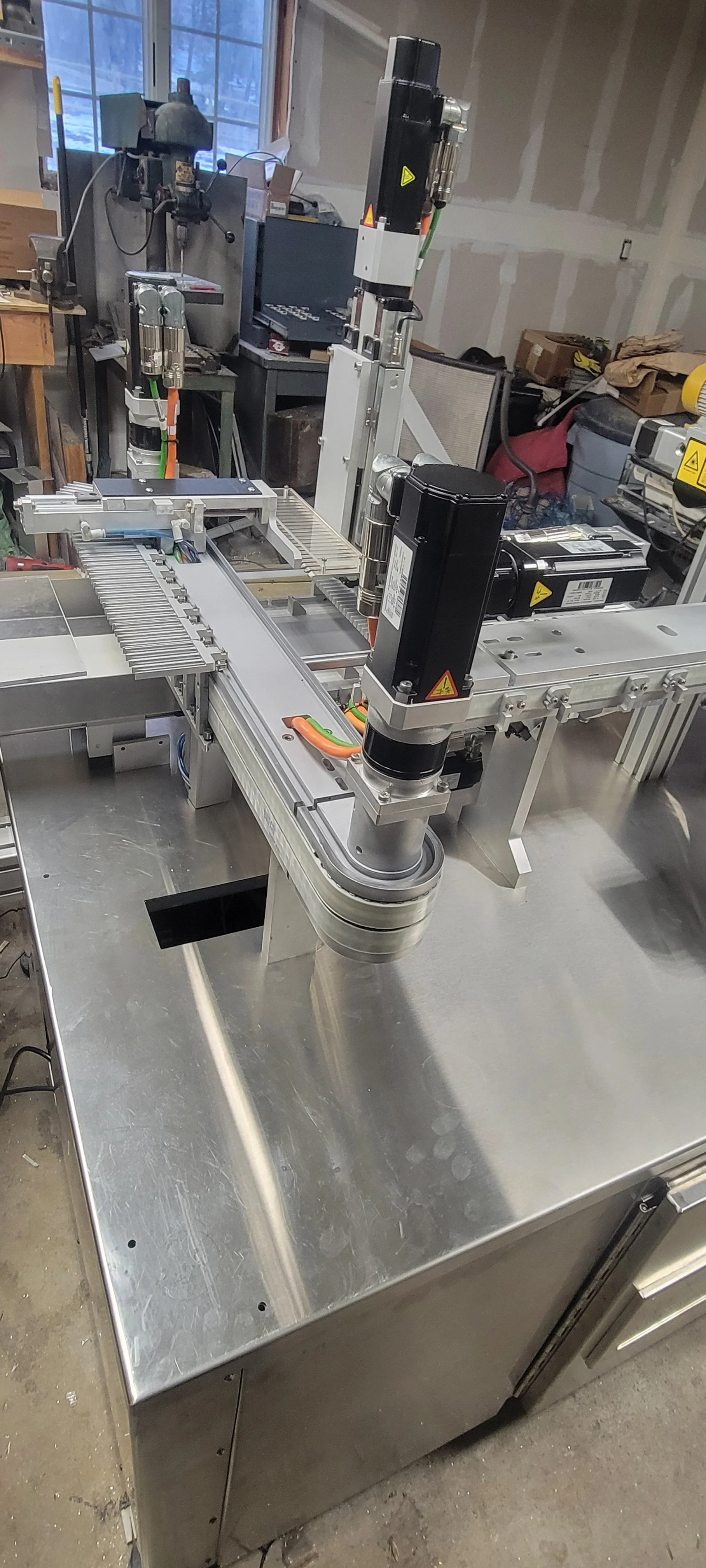 Industrial robotic arm mounted on a metal work table in a workshop or manufacturing setting.